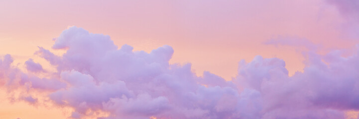Pastel nature Sunset wide banner, purple fluffy clouds on pink colored sky, picturesque landscape pastel tones, soft colorful scenery with vanilla sky, sunlight lighting heaven in bright colors