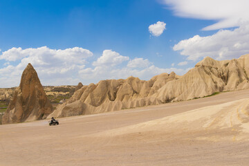 A man driving an off-road vehicle at the Cappadocia region under the cloudy sky