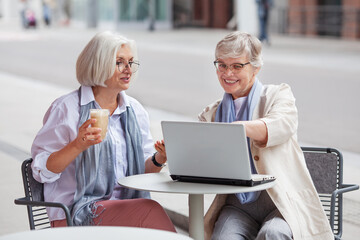 Elderly businesswomen at business meeting in outdoor cafe in the city. Beautiful mature senior...