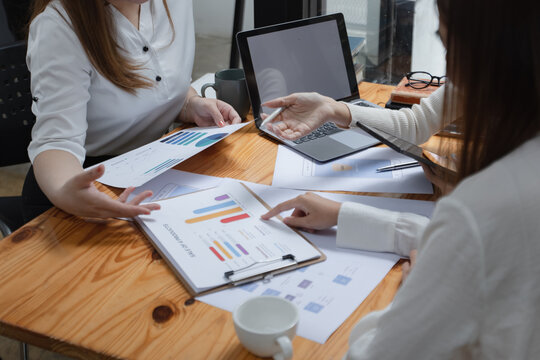 Group of young asian businesswoman working and brainstorming in workshop and analyzing marketing reports startup project infographics in the office.
