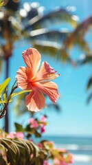 Close-up of a vibrant beach flower in full bloom, with blurred palm trees and a sparkling ocean in the background