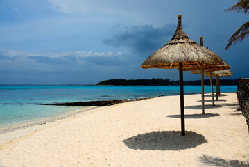 Blue Bay, Grand Port district, Mauritius, Africa - thatched parasols on idyllic sandy beach, Indian Ocean