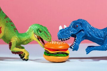 Two cute dinosaurs are fighting over  burger. Humor and fast food concept.