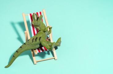 Top view lazy relaxed dinosaur sitting in beach chair on blue background.
