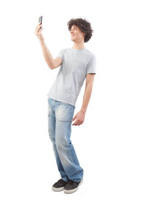 Young happy smiling handsome man using his smartphone, taking a selfie isolated against a white...