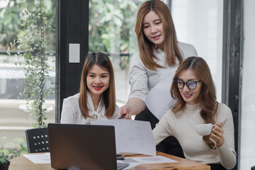 Group of young asian businesswoman working and brainstorming in workshop and analyzing marketing reports startup project infographics in the office.