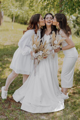 Three women are posing for a picture, one of them is wearing a white dress