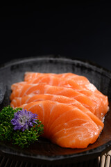 Closeup salmon sashimi on black plate. Japanese food style concept