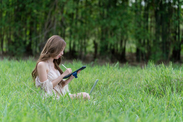 Beautiful woman with laptop and tablet computer and enjoys spring outdoor.