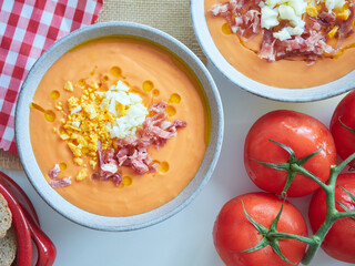 Spanish cold tomato soup called salmorejo. Served in bowls, with chopped hard-boiled egg, diced...
