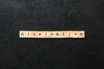 alternative word written on wood block. alternative text on table, concept