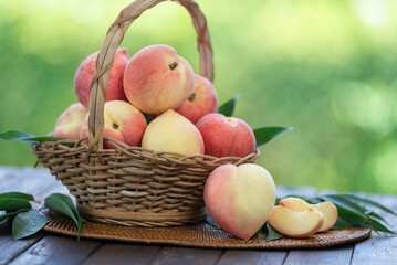 Fresh Peach with sliced on the wooden table over blurred greenery background, Fresh peach on wooden...