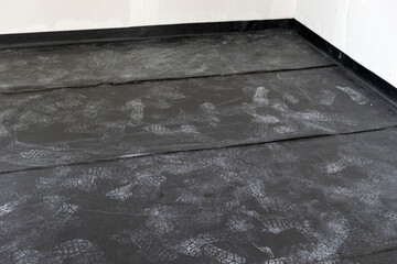 Professional Installation of Black Polyethylene Vapor Barrier on the floor