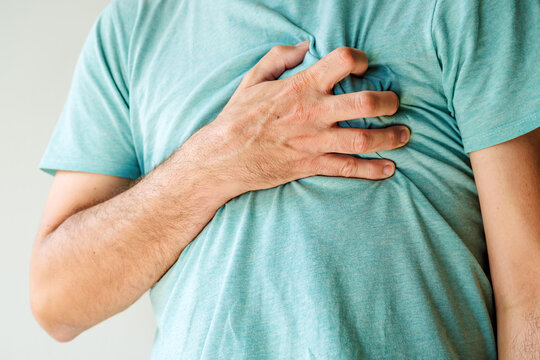 Heartache, chest pain and heart attack concept. Man with painful symptoms of a heart disease.
