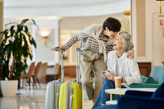 Senior lesbian couple with a suitcase in a hotel hallway.