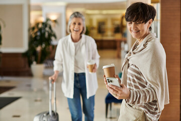 Woman holding coffee cup, checking phone next to her partner.
