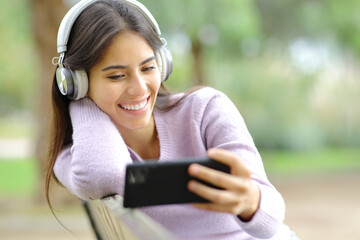 Happy woman watching streaming videos on phone