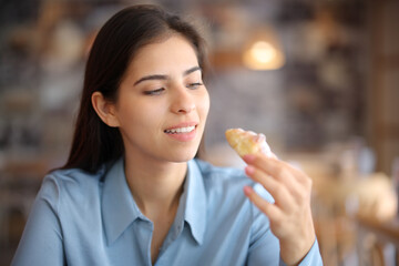 Woman in a restaurant eating bakery