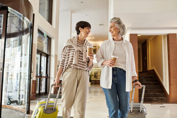Senior lesbian couple, one holding luggage, the other holding hands, ready for adventure.