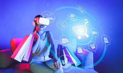 Smart female sitting on sofa while wearing VR headset connecting metaverse, future cyberspace...