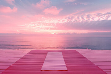 Yoga mat on a wooden pier against a soft pink sunset over the sea