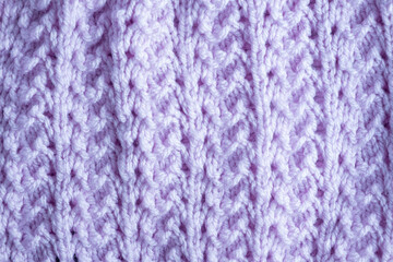 Fragment of hand knitted fabric lilac. beautiful pattern. colorful abstract background