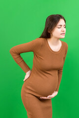 Pregnant woman with a pain in her back on colored Background isolated