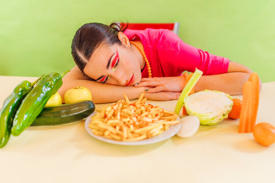 Woman looking at healthy and unhealthy food on table