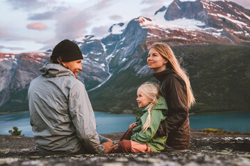 Family mother, father and child  traveling together in Norway summer vacations adventure camping outdoor hiking trip healthy lifestyle parents with kid daughter enjoying mountains and fjord landscape