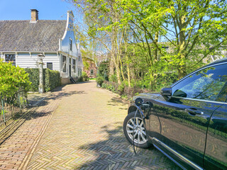 A electric ev car is elegantly parked in front of a charming house, contrasting the modern with the traditional