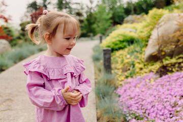 Portrait of smiling child girl in blooming garden