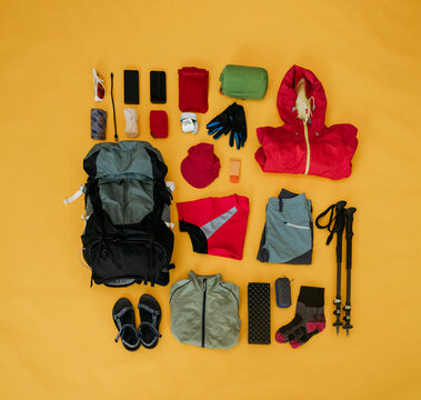Travel kit for hiking organized on yellow background