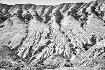 monochrome photo of a mountain with visible layers and traces of erosion in the Altyn Emel National...