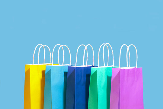 Multi colored shopping bags against blue background