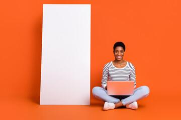Photo of pretty shiny butch lady dressed sweater typing modern gadget empty space isolated orange color background