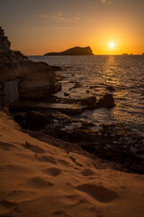 Fishing huts in the sandstone cliff and the sunset view at cala Comte beach, Sant Josep de Sa TalBeautifuaia,  Ibiza, Balearic Islands, Spain