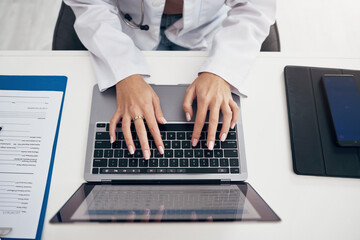 Laptop, hands or doctor typing research, medical update or telehealth web service in hospital...