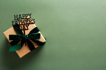Obraz premium Gift box with Happy Fathers Day topper on dark green background.