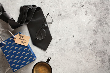 Flat lay composition with tie, coffee cup, eyeglasses, shopping bag on stone background. Fathers...