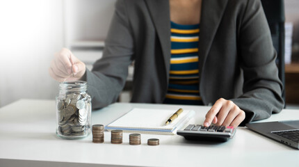 Hand putting mix coins and seed in clear bottle and business investment growth concept. at office..