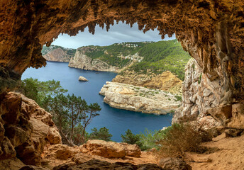 View of the northern coastline cliffs from Egragopilas cave near Portitxol, Sant Joan de Labritja,...