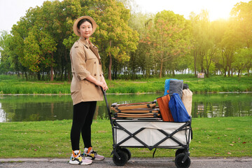 Asian woman pulling a cart full of camping gear