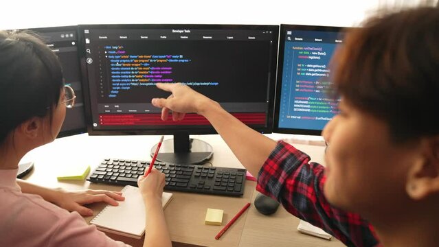 Slow motion back end software developer engineer for computer programming working together on debugging writing computing code, solving complex algorithms display on monitor in office. Burgeoning