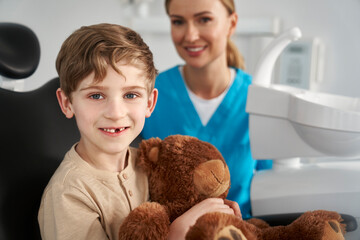 Child holding a teddy bear at the dentist's office