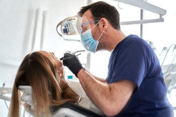 Dentist drilling in teeth of the patient