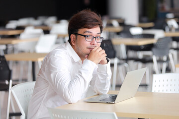 Young business man in glasses with laptop computer working office or online shopping, home work,...