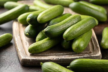 Raw Organic Mini Baby Cucumbers on wooden board. Ready to Eat