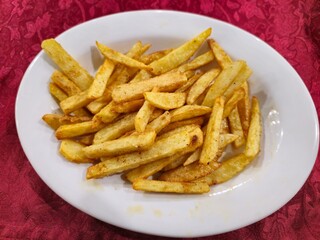 fresh cooked fries in a white plate for kids
