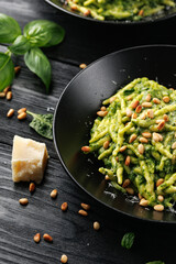 Trofie pasta with creamy spinach sauce and toasted pine nuts