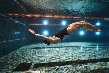 girl doing synchronized swimming in the pool advertising underwater photography